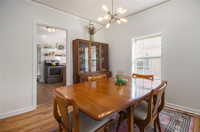 dining space with an inviting chandelier, light wood-style flooring, and baseboards