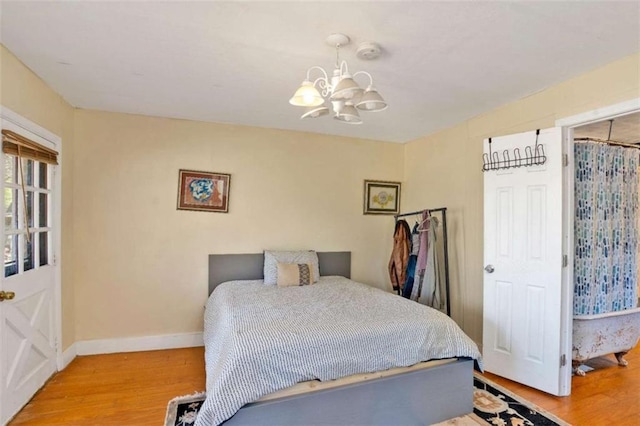 bedroom with hardwood / wood-style flooring and a chandelier