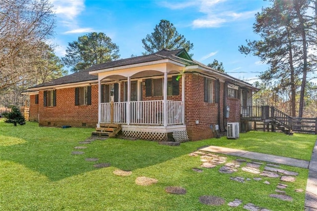 ranch-style home featuring a front yard, central air condition unit, and covered porch