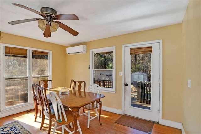 dining room with hardwood / wood-style flooring, ceiling fan, and a wall unit AC