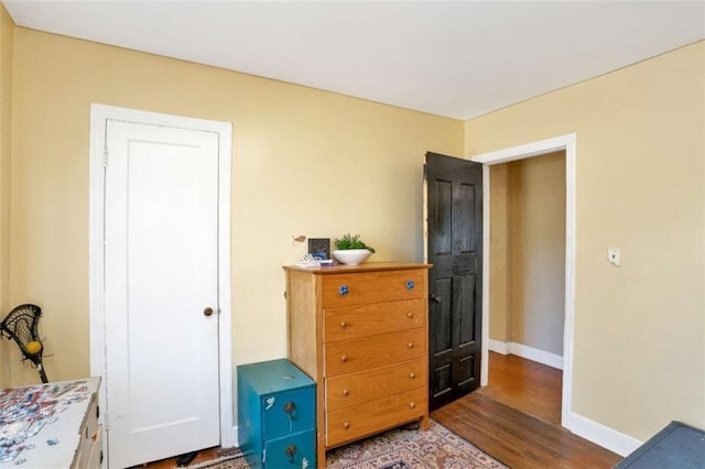 bedroom with dark hardwood / wood-style floors