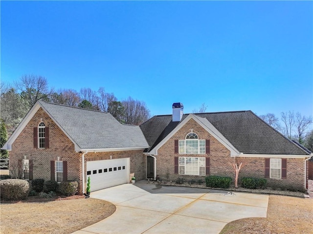 traditional-style house featuring a garage, driveway, brick siding, and a chimney