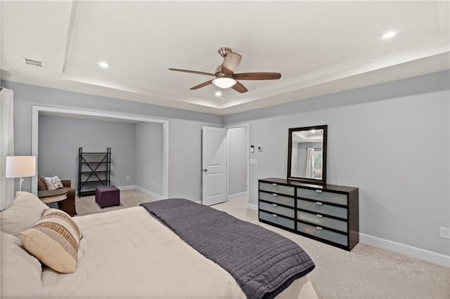 bedroom with a tray ceiling, light carpet, baseboards, recessed lighting, and a ceiling fan