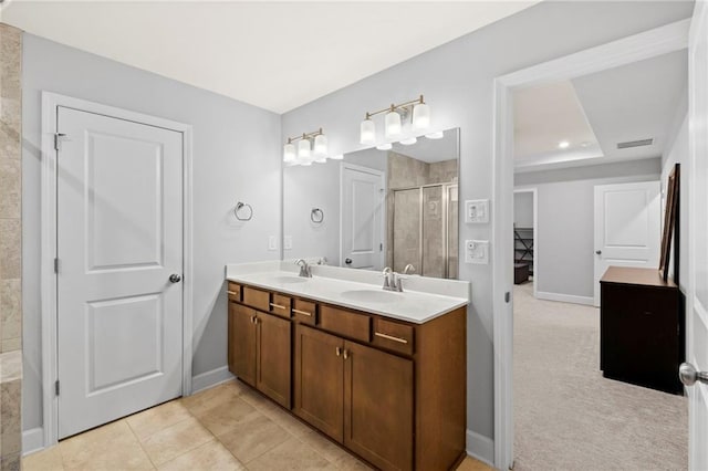 full bathroom featuring a stall shower, double vanity, baseboards, a tray ceiling, and tile patterned floors
