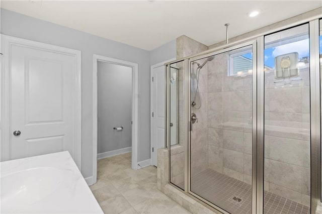 full bathroom featuring a shower stall and baseboards