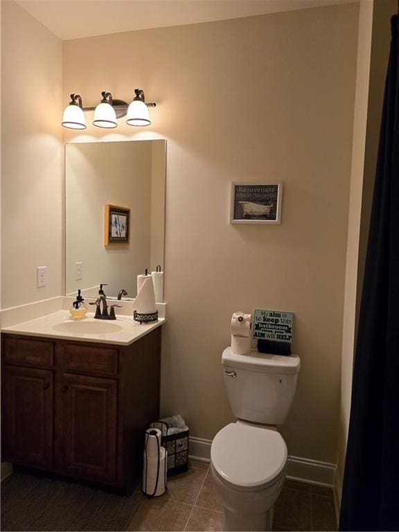 bathroom featuring toilet, tile patterned flooring, and vanity