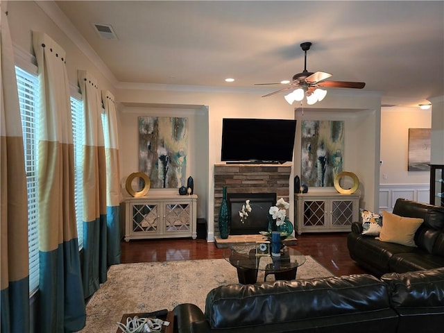 living room featuring ceiling fan, a stone fireplace, and dark hardwood / wood-style flooring