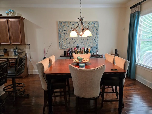 dining room featuring crown molding, dark hardwood / wood-style floors, and a chandelier