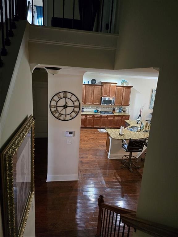 kitchen with a high ceiling, decorative backsplash, and dark hardwood / wood-style flooring