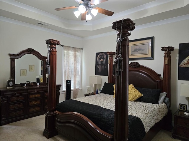 carpeted bedroom with a tray ceiling, ceiling fan, and ornamental molding