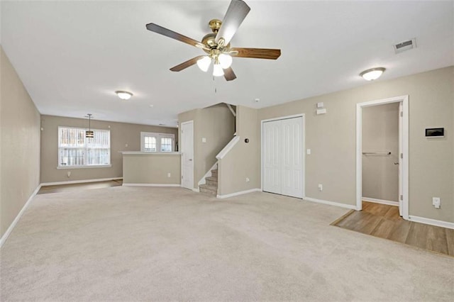 unfurnished living room with ceiling fan and light colored carpet