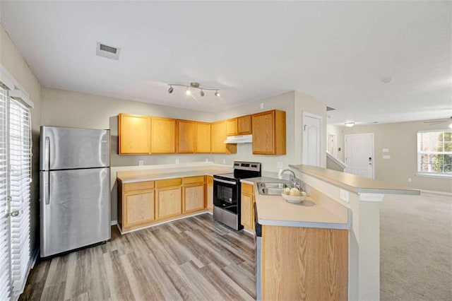 kitchen featuring kitchen peninsula, light hardwood / wood-style flooring, sink, appliances with stainless steel finishes, and light brown cabinets