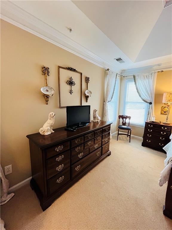 bedroom featuring light carpet, baseboards, visible vents, and ornamental molding