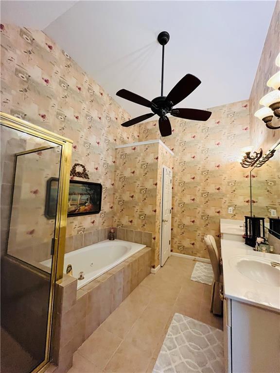 full bathroom with a shower stall, baseboards, a garden tub, tile patterned floors, and vanity