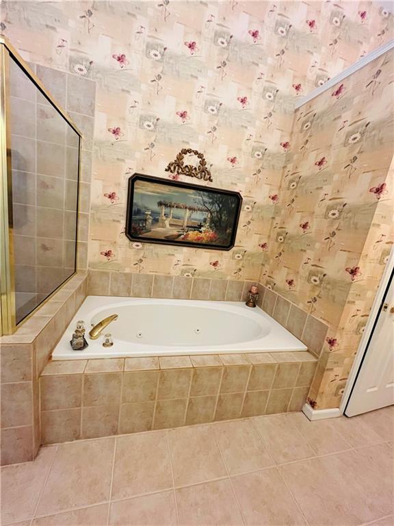 full bathroom with tile patterned flooring and a tub with jets