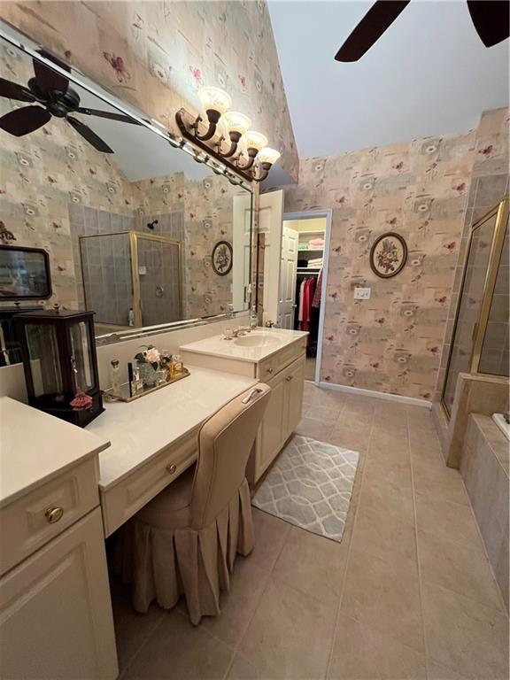 bathroom featuring wallpapered walls, vaulted ceiling, a stall shower, and ceiling fan