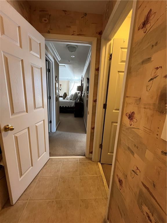 hallway with light tile patterned floors and light carpet