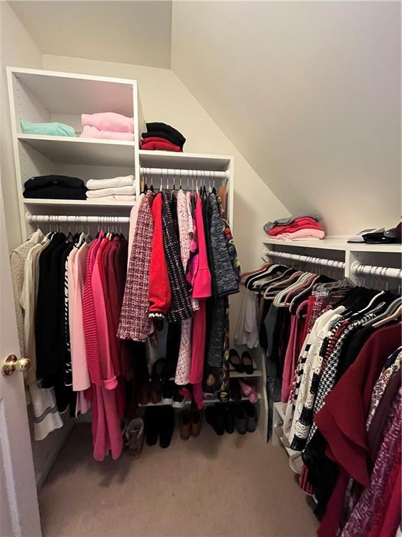 spacious closet featuring vaulted ceiling and carpet flooring