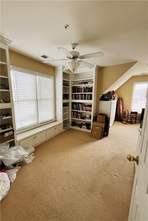 interior space with visible vents, ceiling fan, and carpet flooring