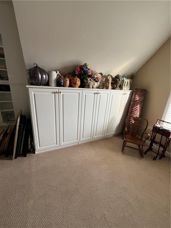 sitting room featuring light colored carpet and lofted ceiling