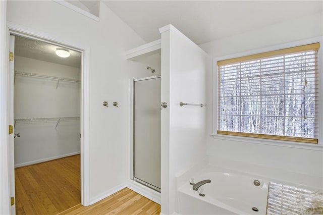 bathroom featuring wood-type flooring and plus walk in shower