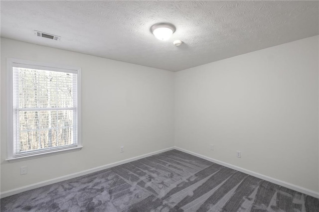 carpeted spare room featuring a textured ceiling