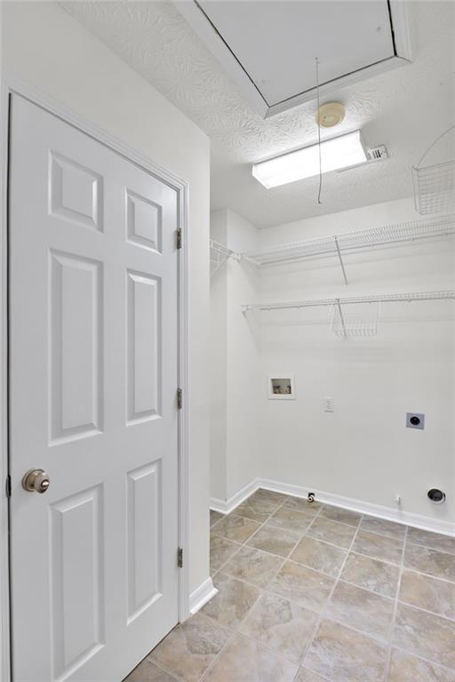 laundry area featuring gas dryer hookup, washer hookup, hookup for an electric dryer, and a textured ceiling