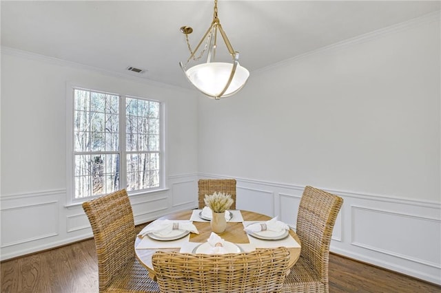 dining room featuring ornamental molding and dark hardwood / wood-style floors