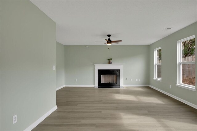 unfurnished living room featuring light hardwood / wood-style floors and ceiling fan