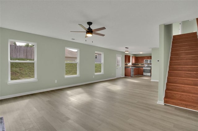 unfurnished living room with ceiling fan and light hardwood / wood-style flooring