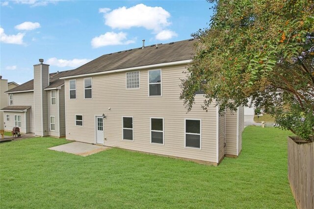 rear view of house featuring a patio and a yard