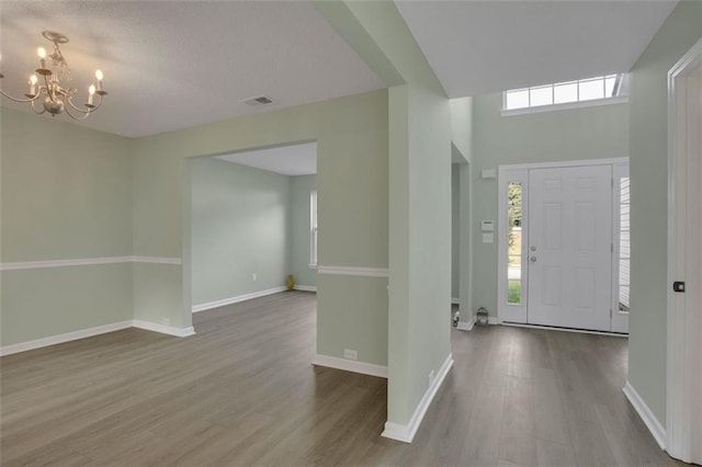 entryway with a notable chandelier and wood-type flooring