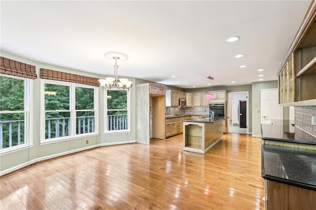 8464 Pleasant Hill Rd, Lithonia, GA 30058 - kitchen with a chandelier, backsplash, light wood-type flooring, hanging light fixtures, and double oven