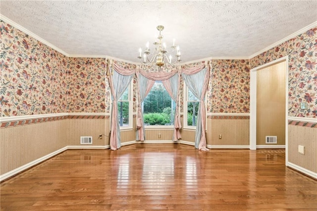 8464 Pleasant Hill Rd, Lithonia, GA 30058 - unfurnished dining area featuring wallpapered walls, wood finished floors, a wainscoted wall, a chandelier, and a textured ceiling