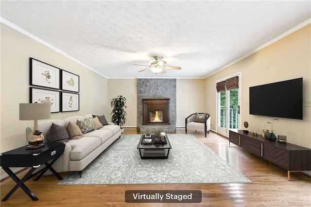 8464 Pleasant Hill Rd, Lithonia, GA 30058 - living area featuring ceiling fan, ornamental molding, light wood-type flooring, a fireplace, and a textured ceiling