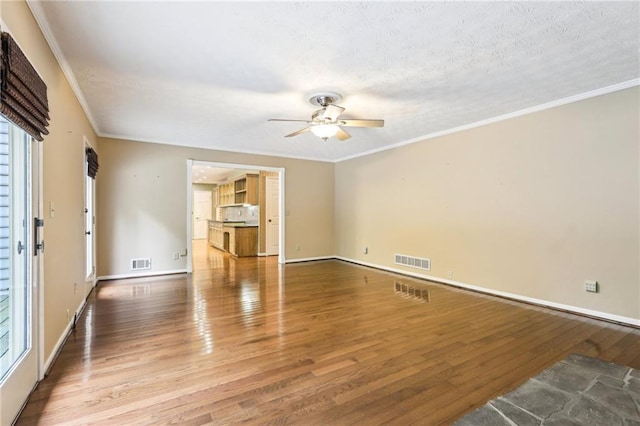 8464 Pleasant Hill Rd, Lithonia, GA 30058 - unfurnished living room with ceiling fan, wood finished floors, crown molding, baseboards, and a textured ceiling