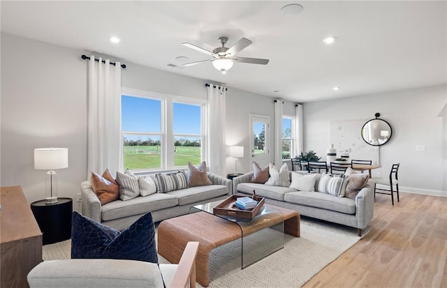 living room featuring ceiling fan and light hardwood / wood-style flooring