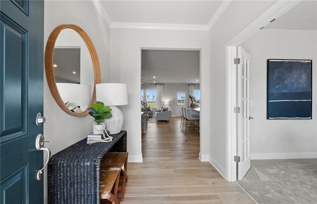 entryway with crown molding and light hardwood / wood-style flooring