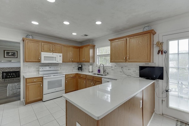 kitchen with light tile patterned flooring, sink, white appliances, and kitchen peninsula