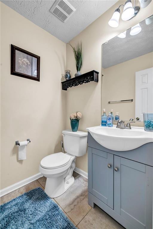 half bathroom featuring visible vents, toilet, a textured ceiling, baseboards, and vanity