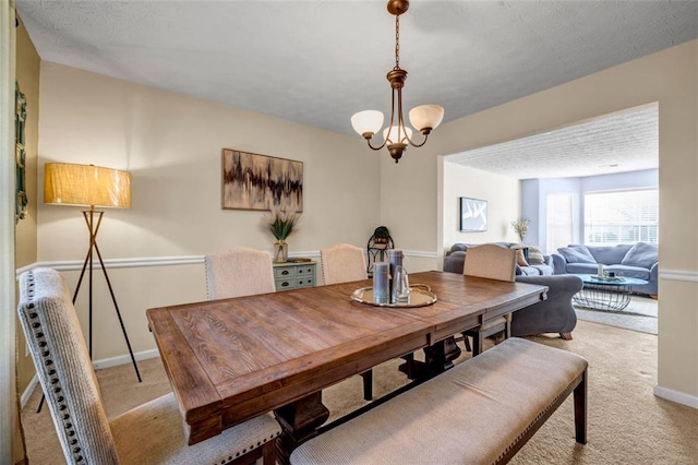 dining area featuring a notable chandelier, carpet, and baseboards
