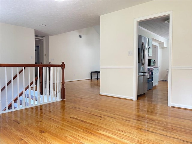 30 Buck Trl, Newnan, GA 30265 - spare room featuring light wood-style flooring, a textured ceiling, and baseboards