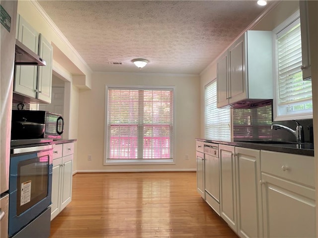 30 Buck Trl, Newnan, GA 30265 - kitchen with a sink, light wood-style flooring, dark countertops, wall oven, and crown molding