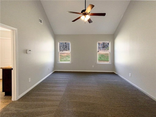 spare room with visible vents, dark carpet, a ceiling fan, high vaulted ceiling, and baseboards