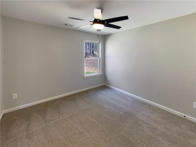 empty room with ceiling fan, carpet flooring, visible vents, and baseboards