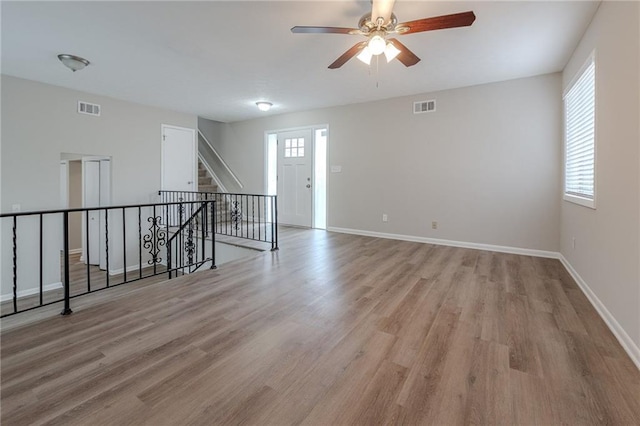 spare room with ceiling fan, plenty of natural light, and light hardwood / wood-style flooring