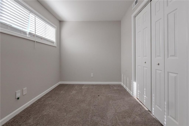 unfurnished bedroom with dark carpet