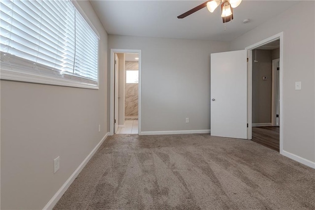 unfurnished bedroom featuring light carpet, ensuite bathroom, and ceiling fan