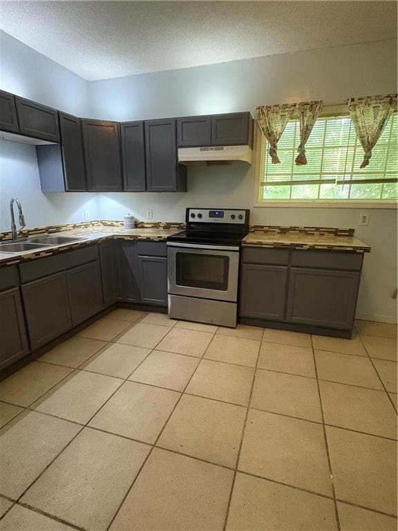 3831 Fairmont Ave, Macon, GA 31204 - kitchen with electric range, a sink, under cabinet range hood, gray cabinets, and light tile patterned floors