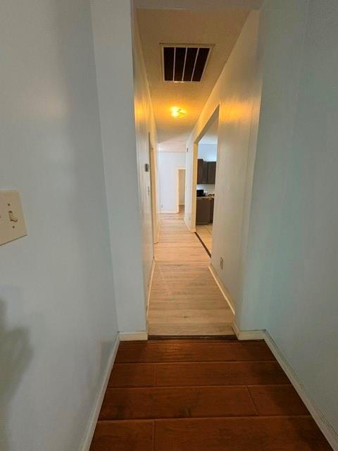 corridor featuring wood finished floors and baseboards